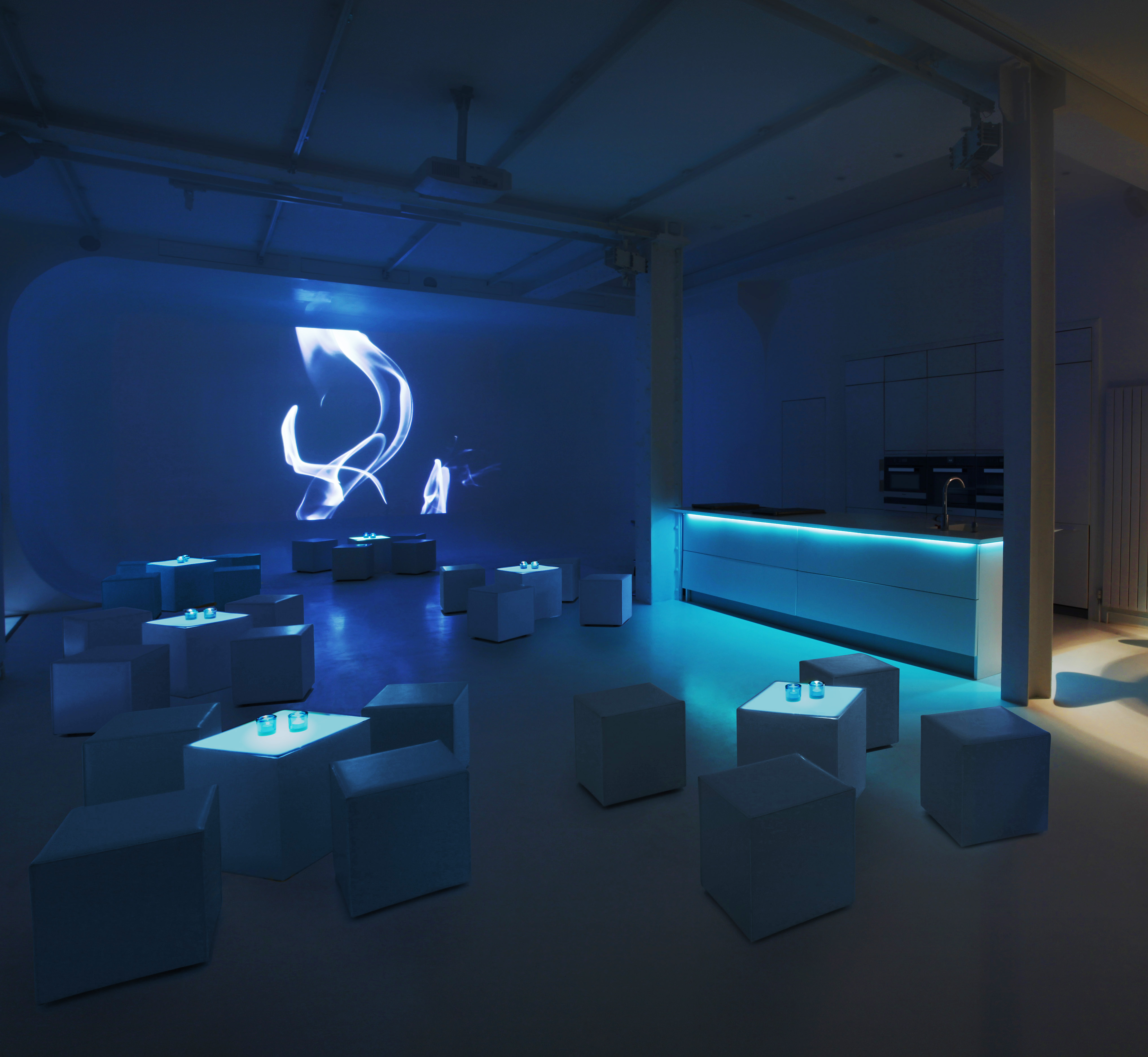 Modern event space with blue lighting for cocktail receptions and networking events.