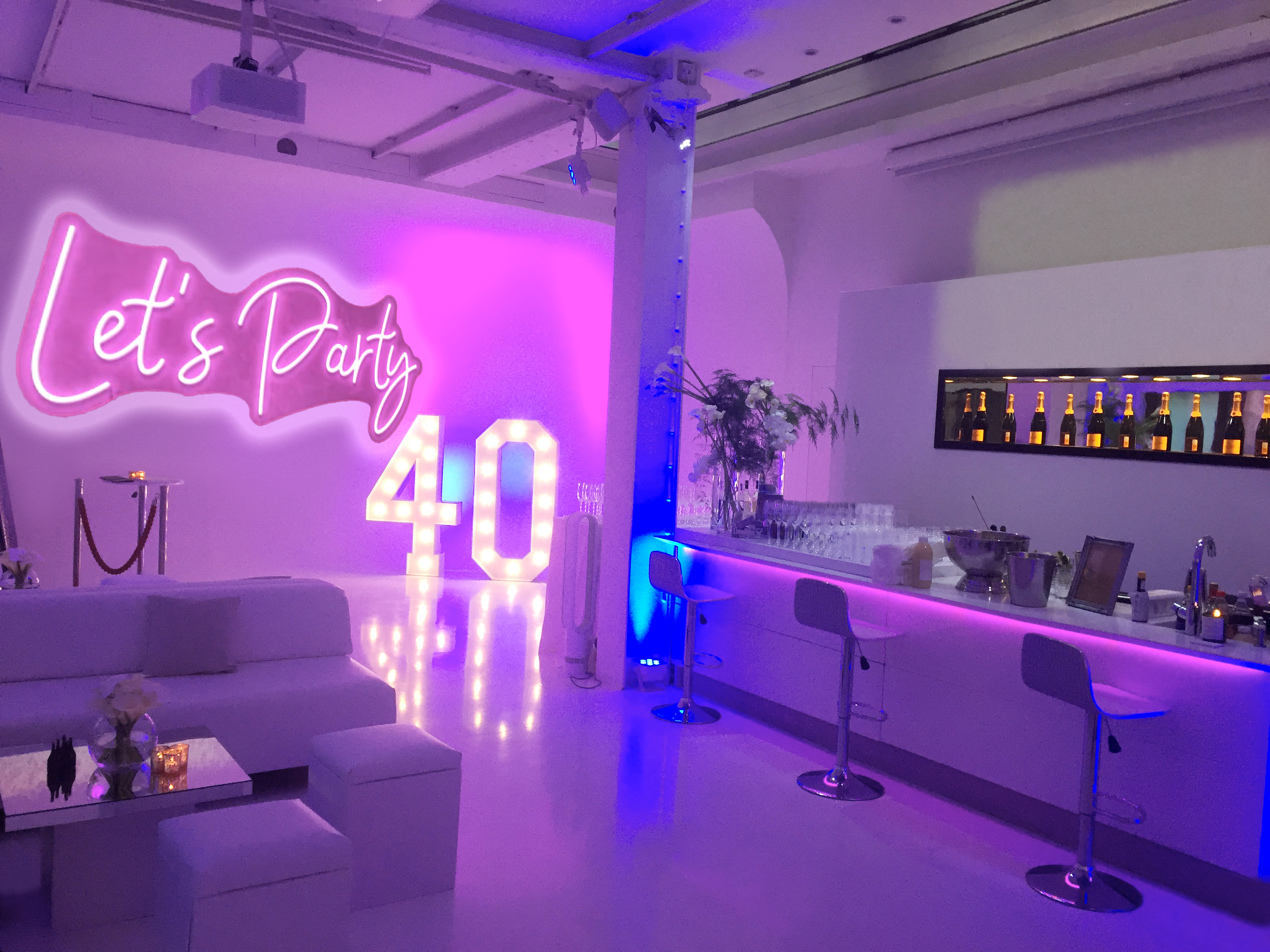 Vibrant 40th birthday drink reception at Icetank with neon decor and sleek bar.