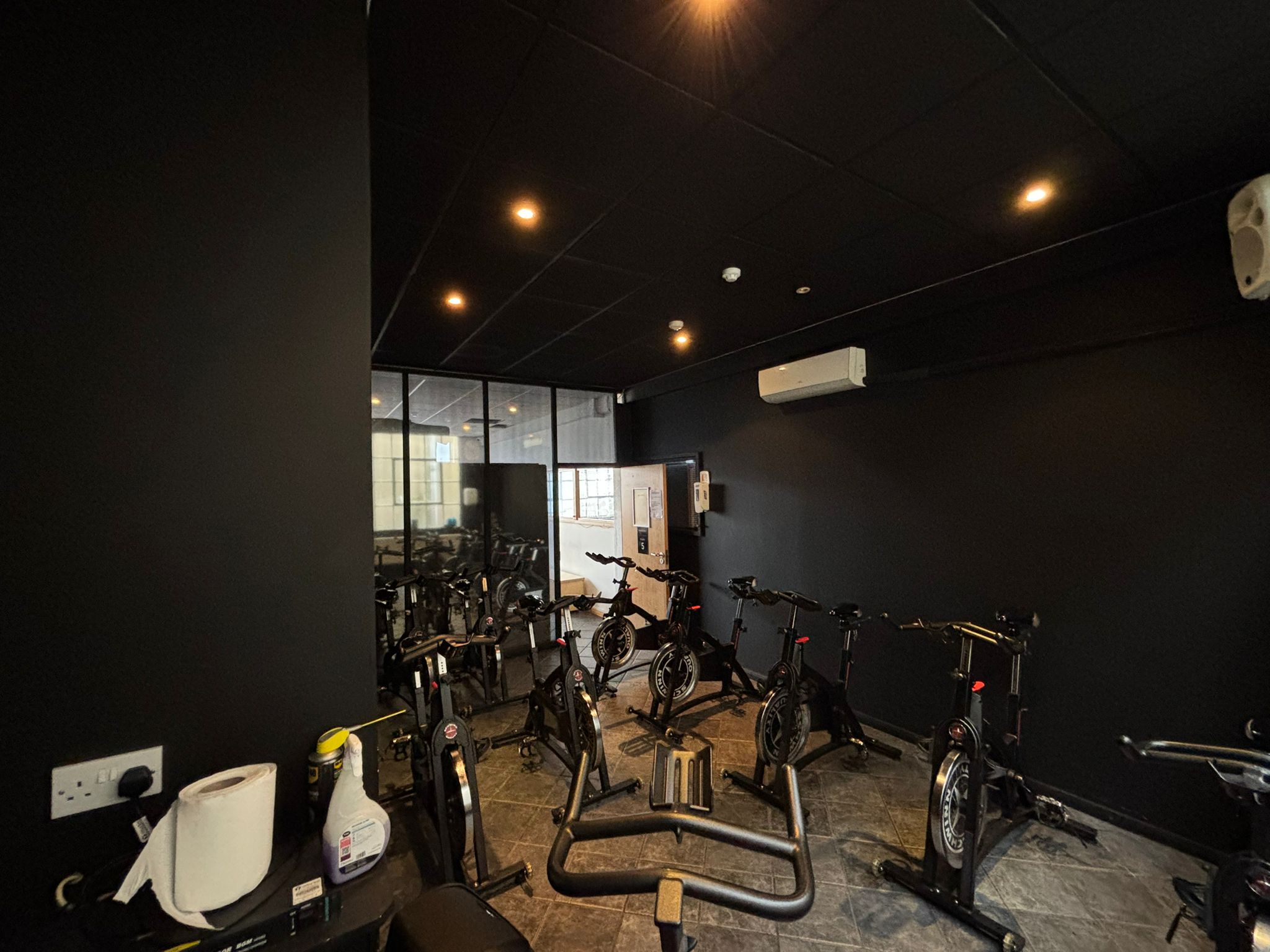 Modern fitness studio with dark walls, ideal for cycling classes and wellness retreats.