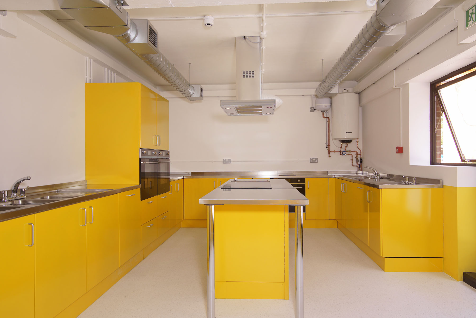 Bright modern kitchen with yellow cabinetry for culinary events and cooking classes.