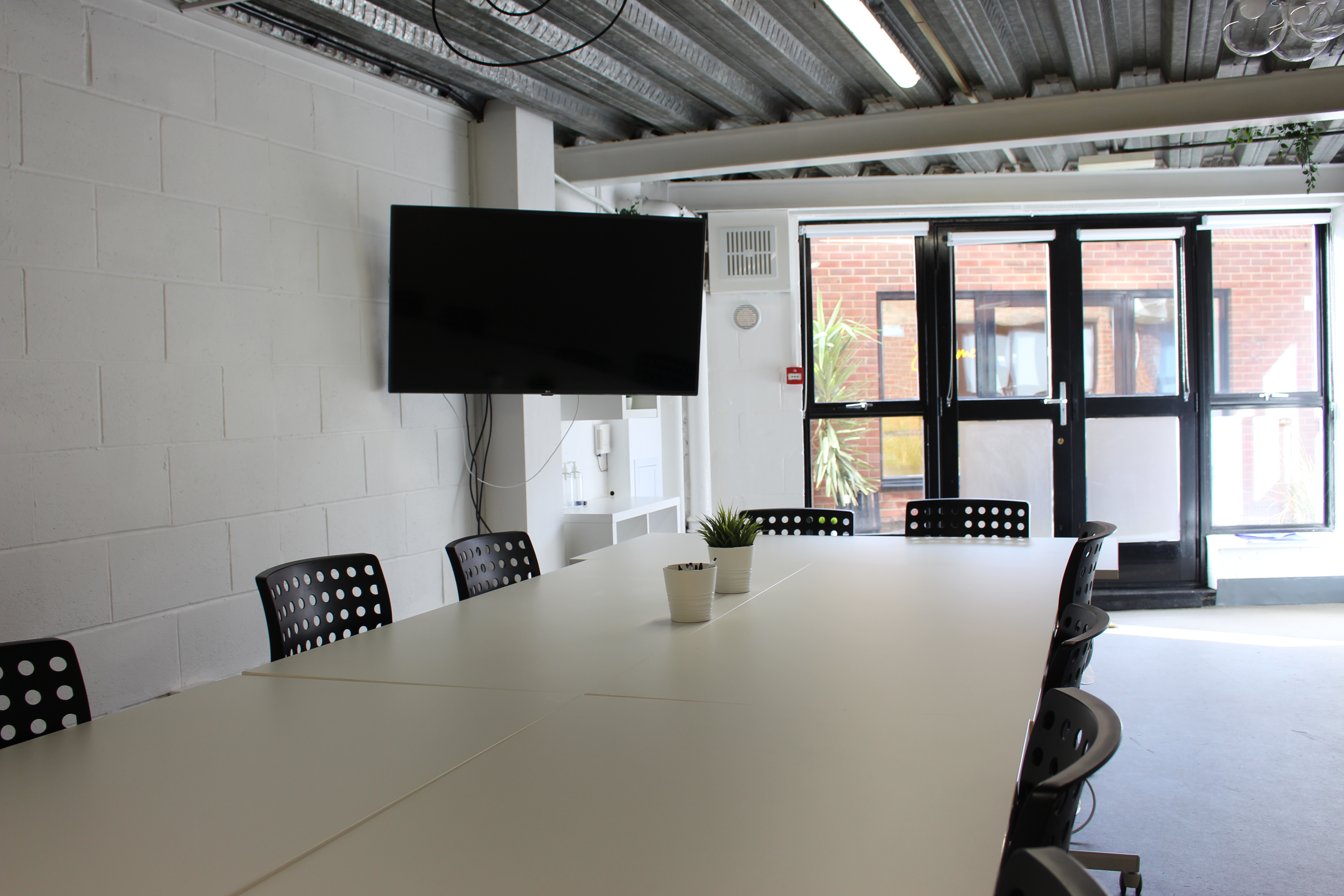 Modern meeting room in Tooting Works with spacious table for collaboration and presentations.