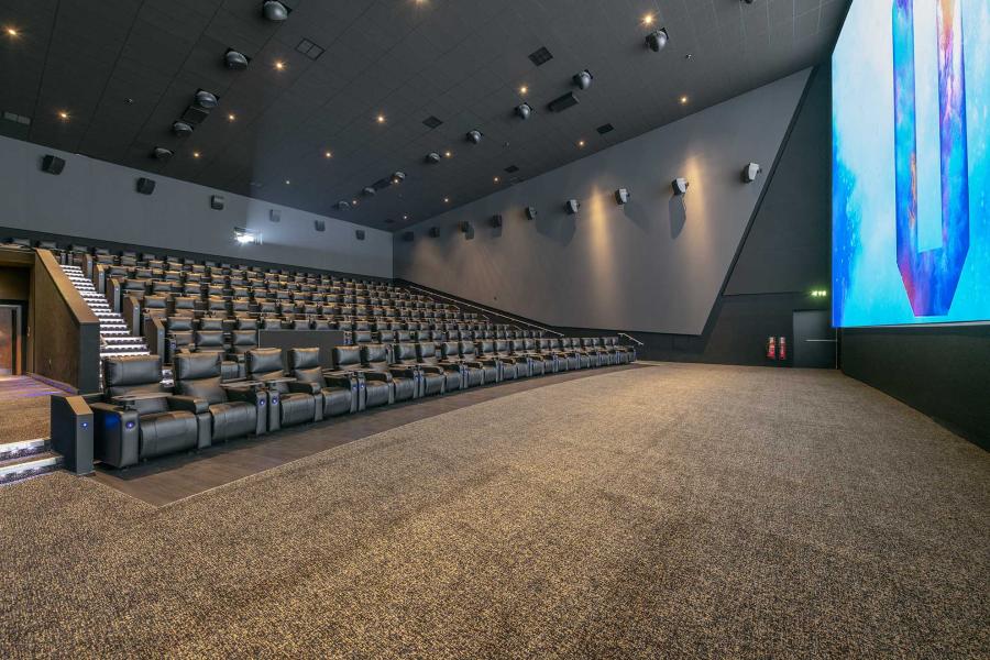 Modern auditorium with tiered seating and large screen for conferences or film screenings.