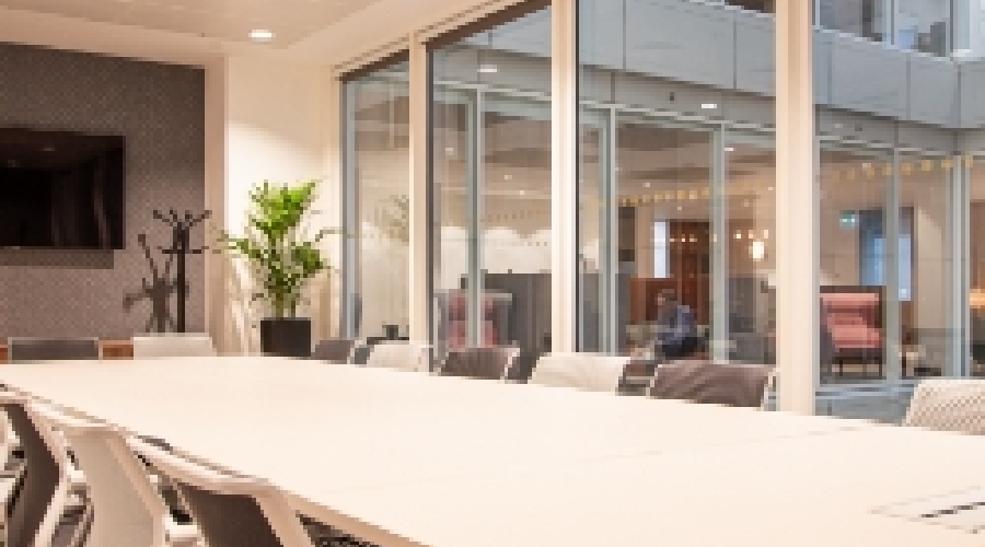 Modern conference room with glass walls, ideal for meetings and presentations.