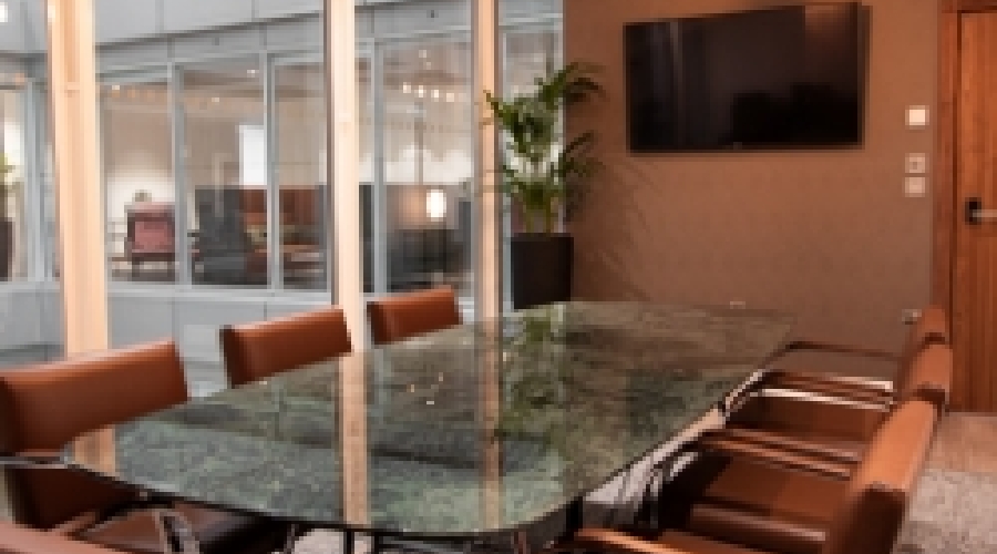 Modern conference room with glass table, ideal for meetings and events.