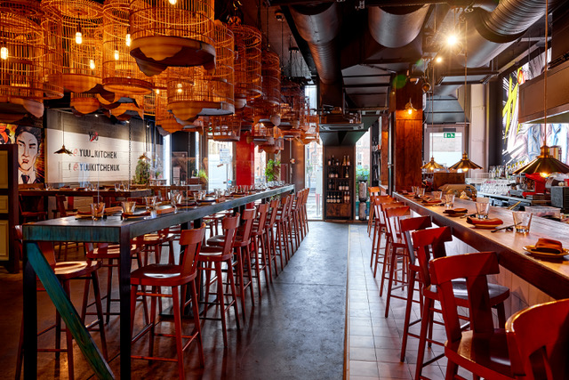 Vibrant Yuu Kitchen bar with warm lighting, perfect for networking events and gatherings.