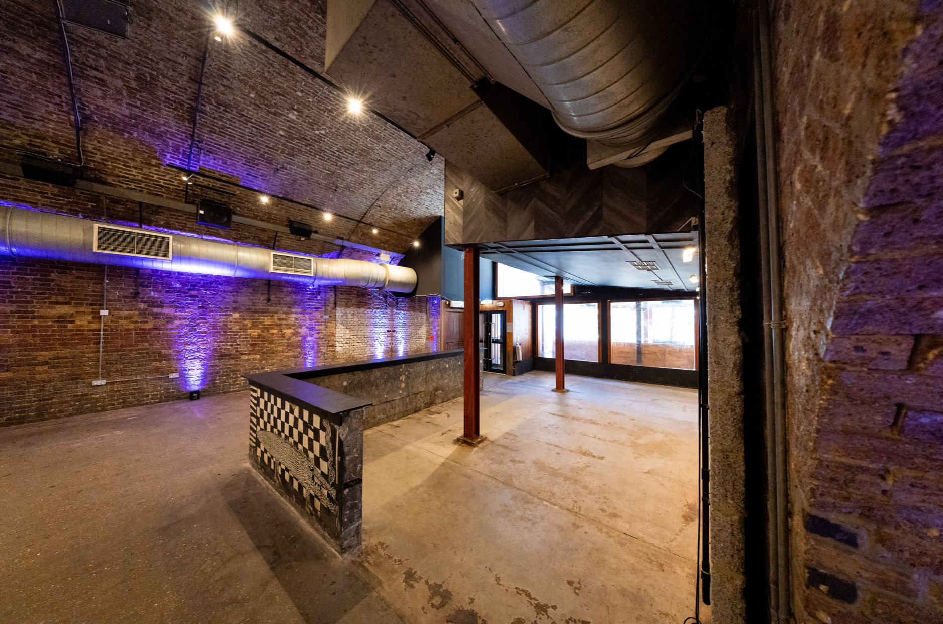 Versatile event space with exposed brick walls, ideal for corporate meetings and social events.
