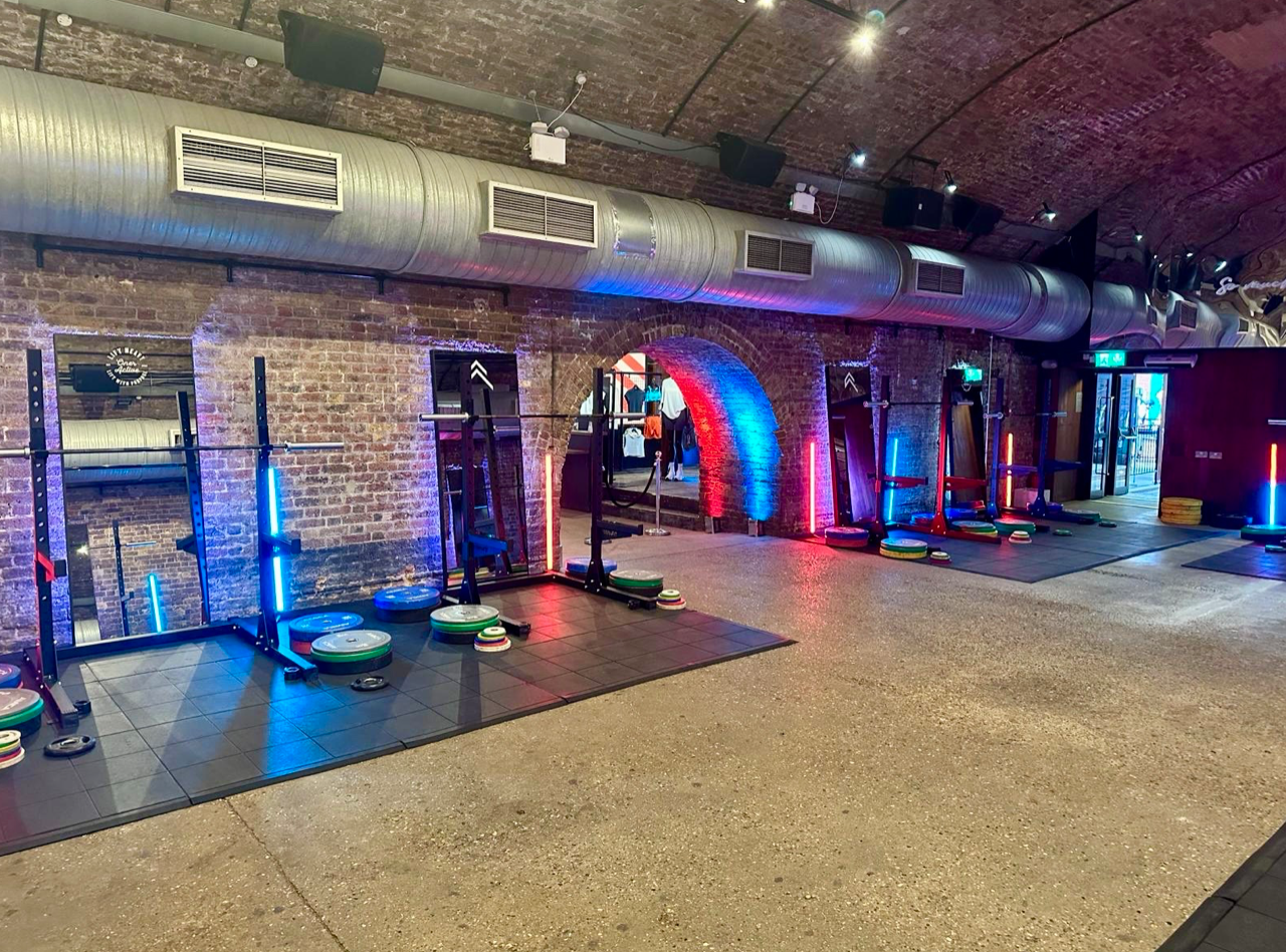 Dynamic fitness event space with sleek equipment and vibrant lighting at 83 Rivington Street.