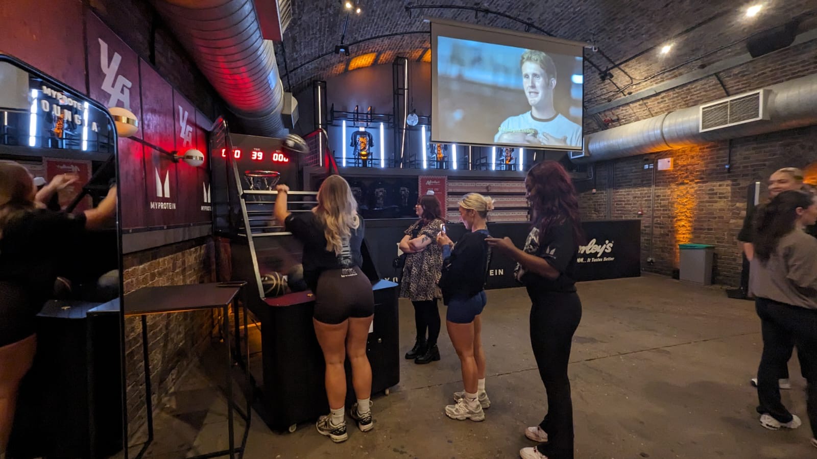 Dynamic event space at 83 Rivington St with large screen for networking and presentations.