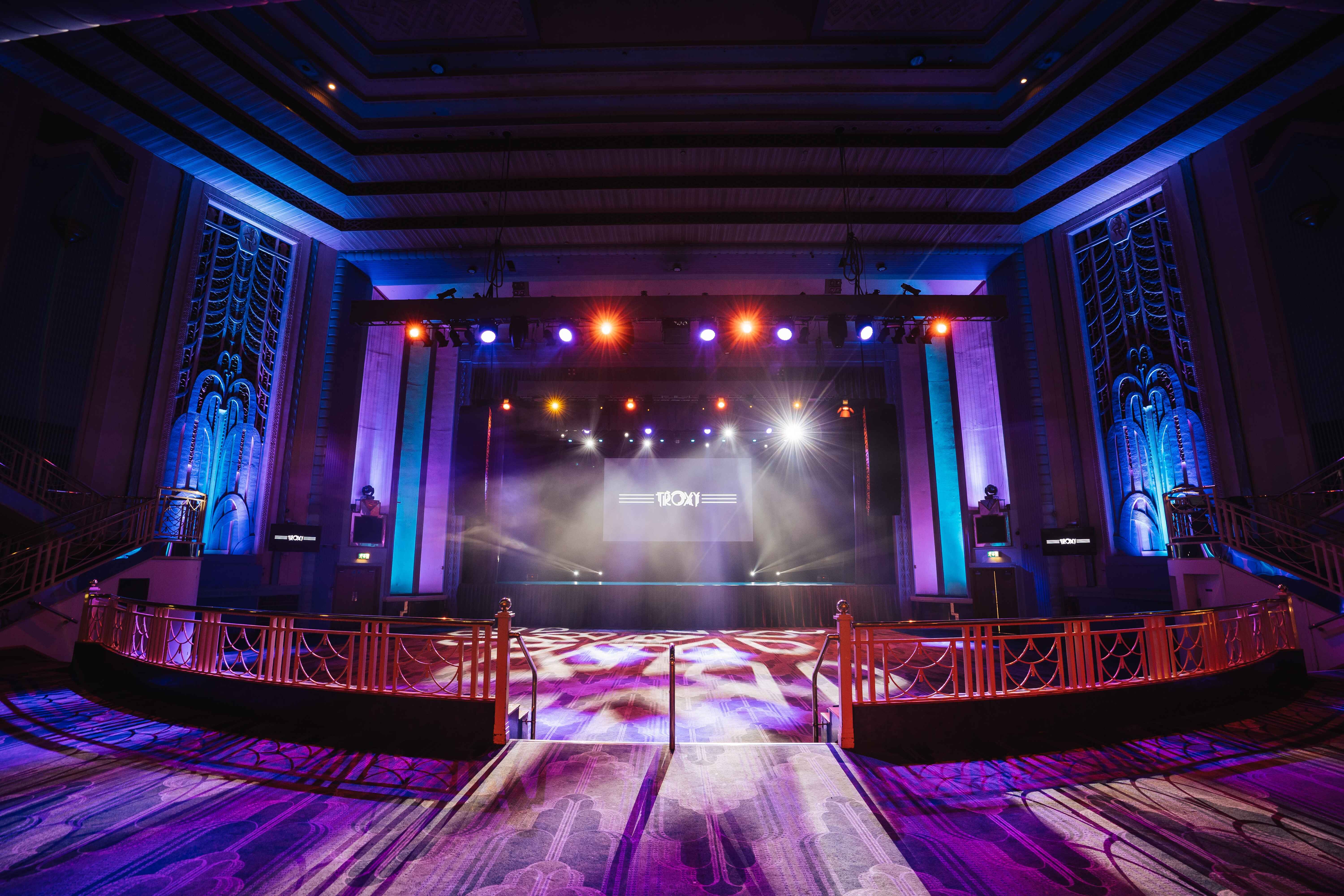 Elegant Grand Hall in Troxy with vibrant stage lighting for conferences and gala events.