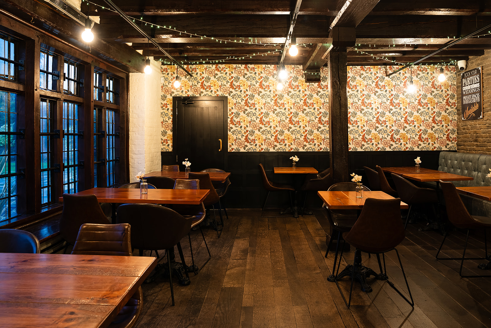 Cozy Tudor Gallery dining space with floral wallpaper for intimate gatherings and meetings.