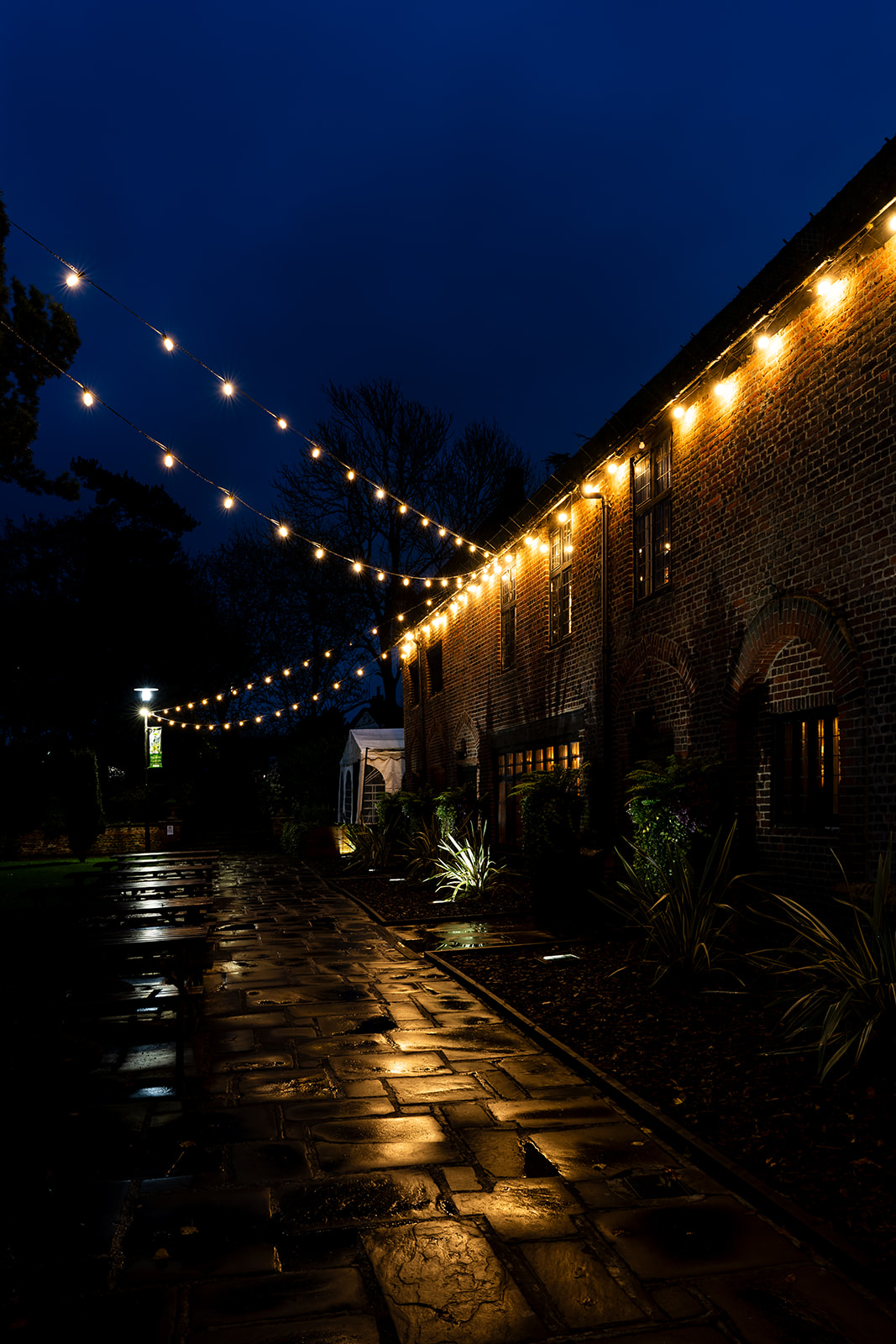Illuminated Tudor Gallery venue with string lights, perfect for weddings and receptions.