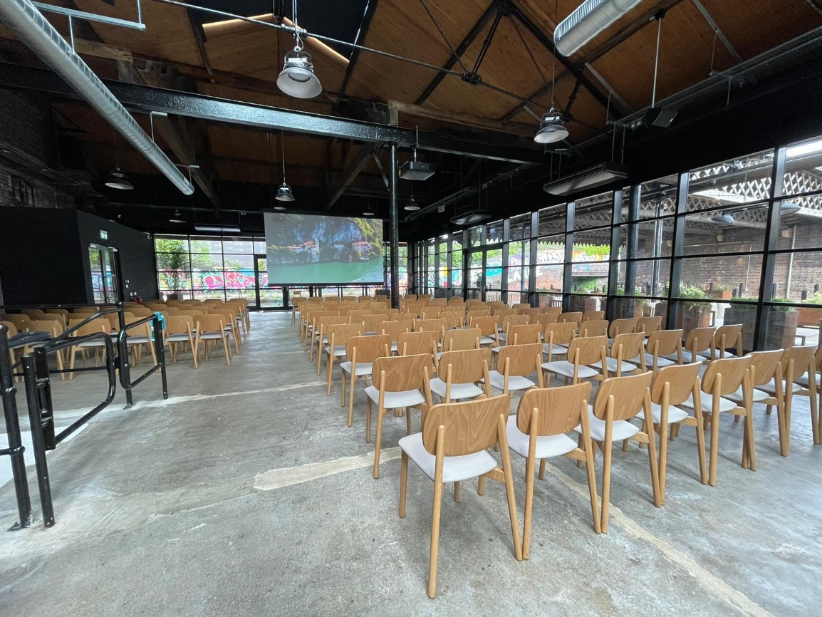 Spacious event venue at The Bond, featuring wooden chairs for presentations and natural light.