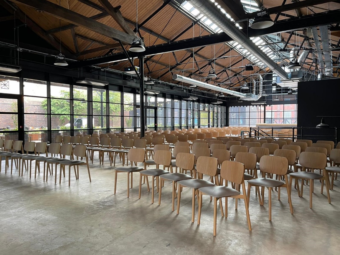 Modern event venue with wooden chairs and natural light at The Canopy, Fazeley Studios.