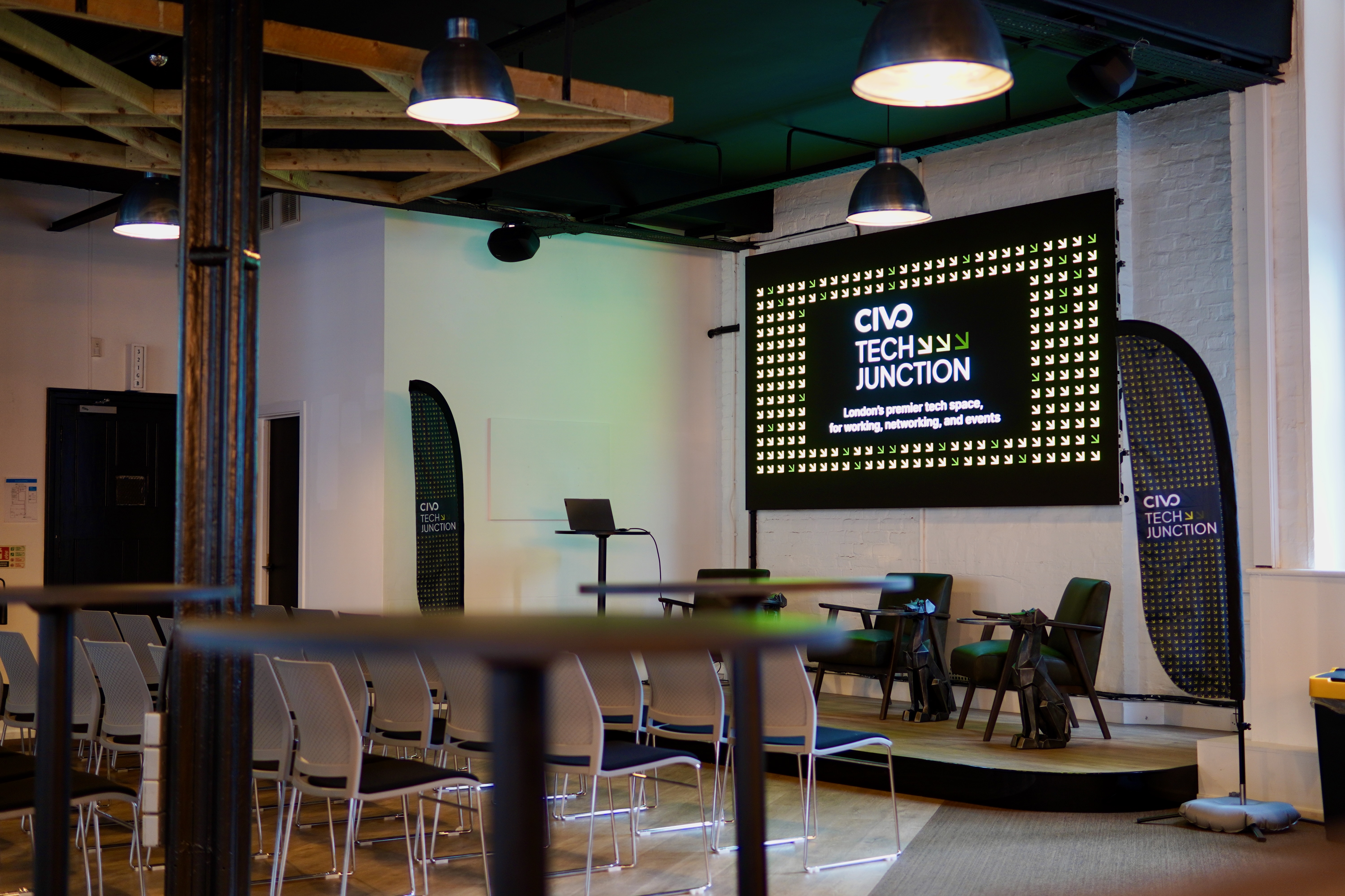 Modern tech event space at Civo Tech Junction with large screen and flexible seating.