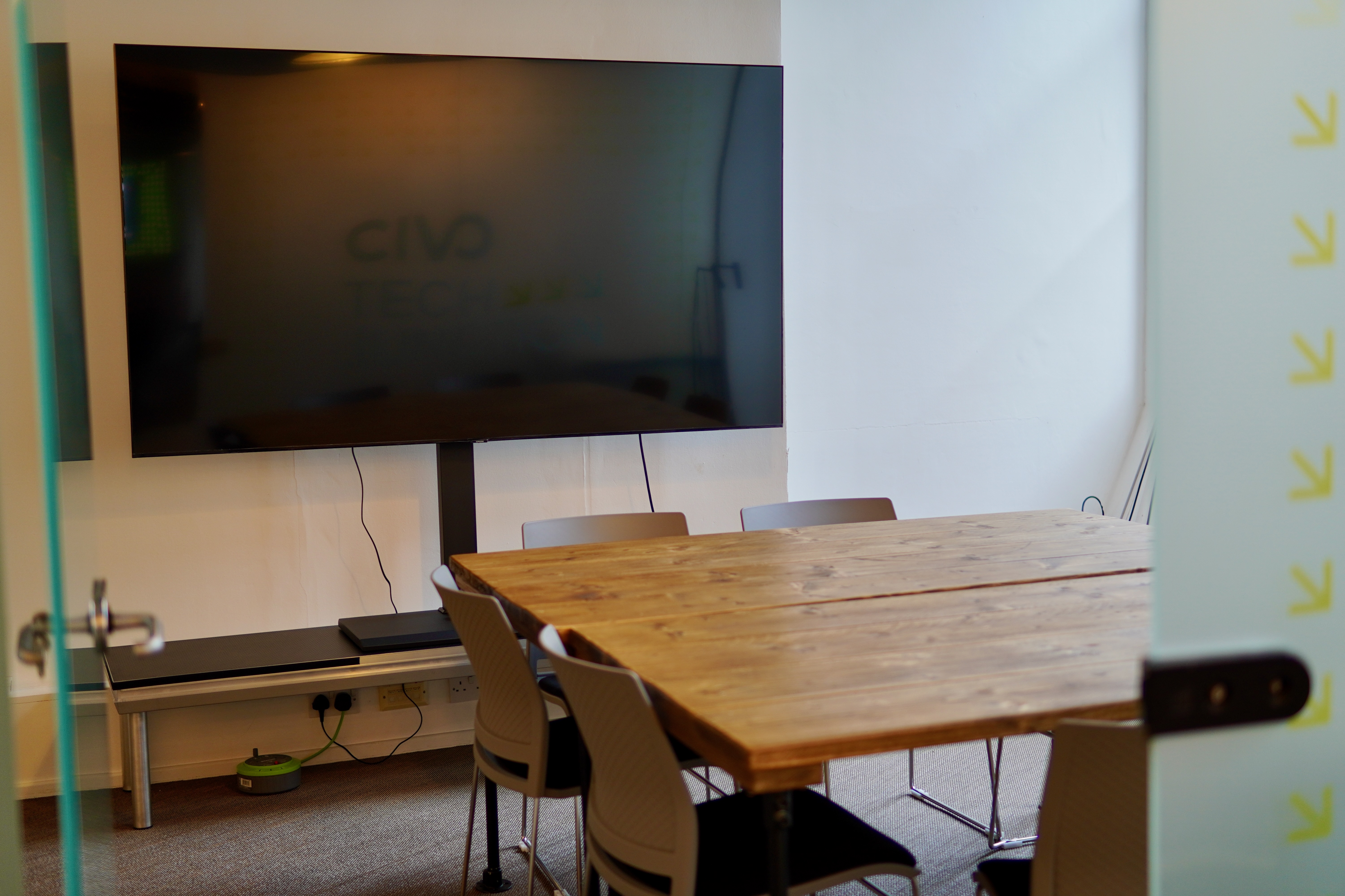Modern meeting room at Civo Tech Junction with large screen, ideal for collaborative sessions.