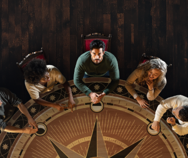 Diverse group at round table in The Traitors Live Experience, ideal for meetings and brainstorming.