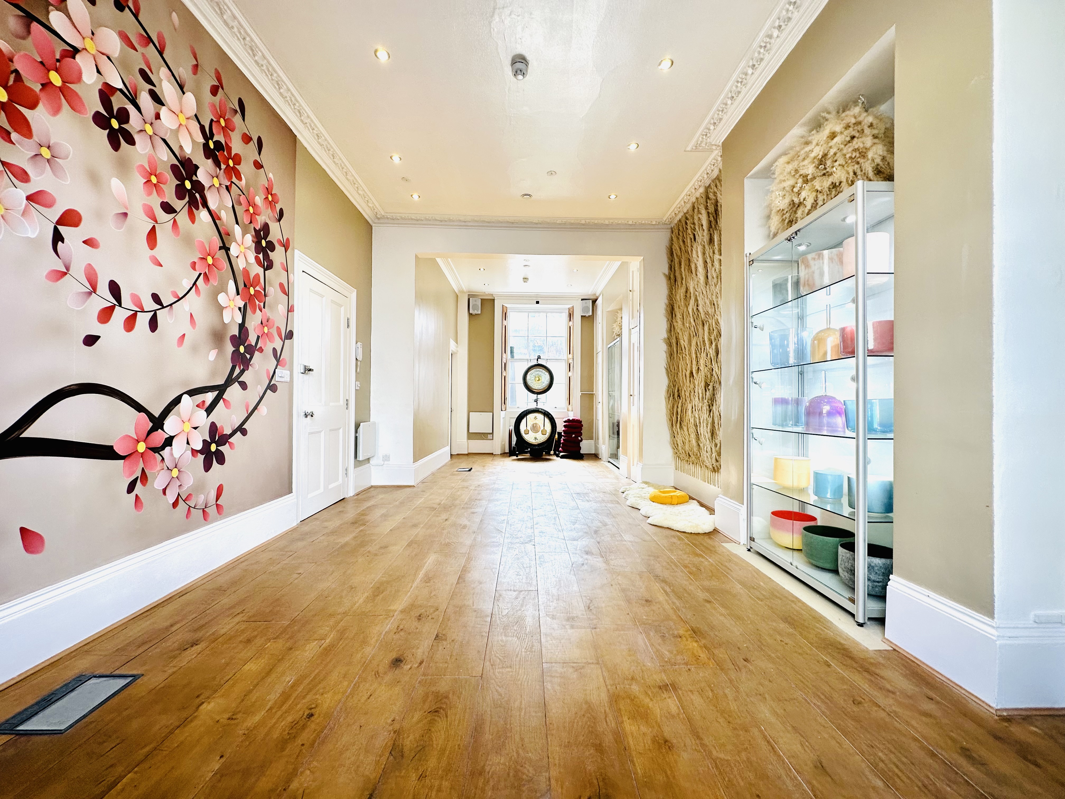 Spacious studio corridor with floral mural for networking events and gatherings.