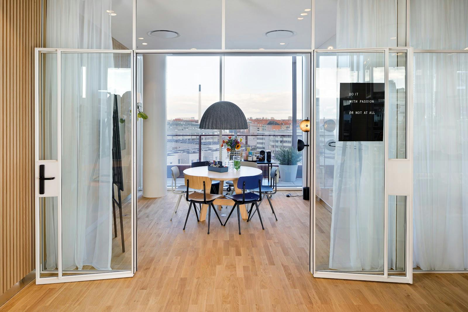Modern meeting room with large glass doors, ideal for collaborative discussions and events.
