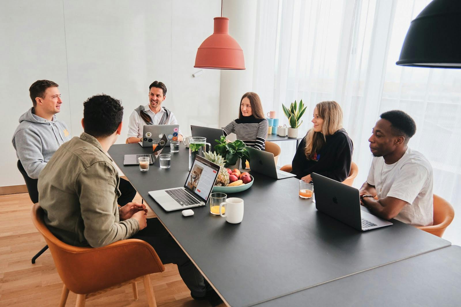 Modern meeting room with professionals collaborating in a bright, inviting space.