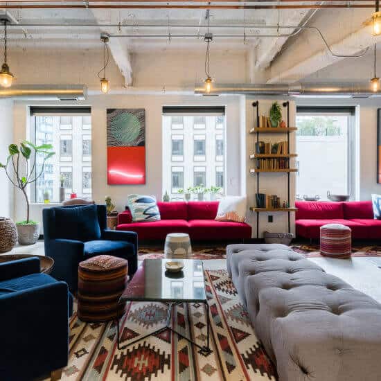Inviting lounge area with red couches for informal meetings and networking events.