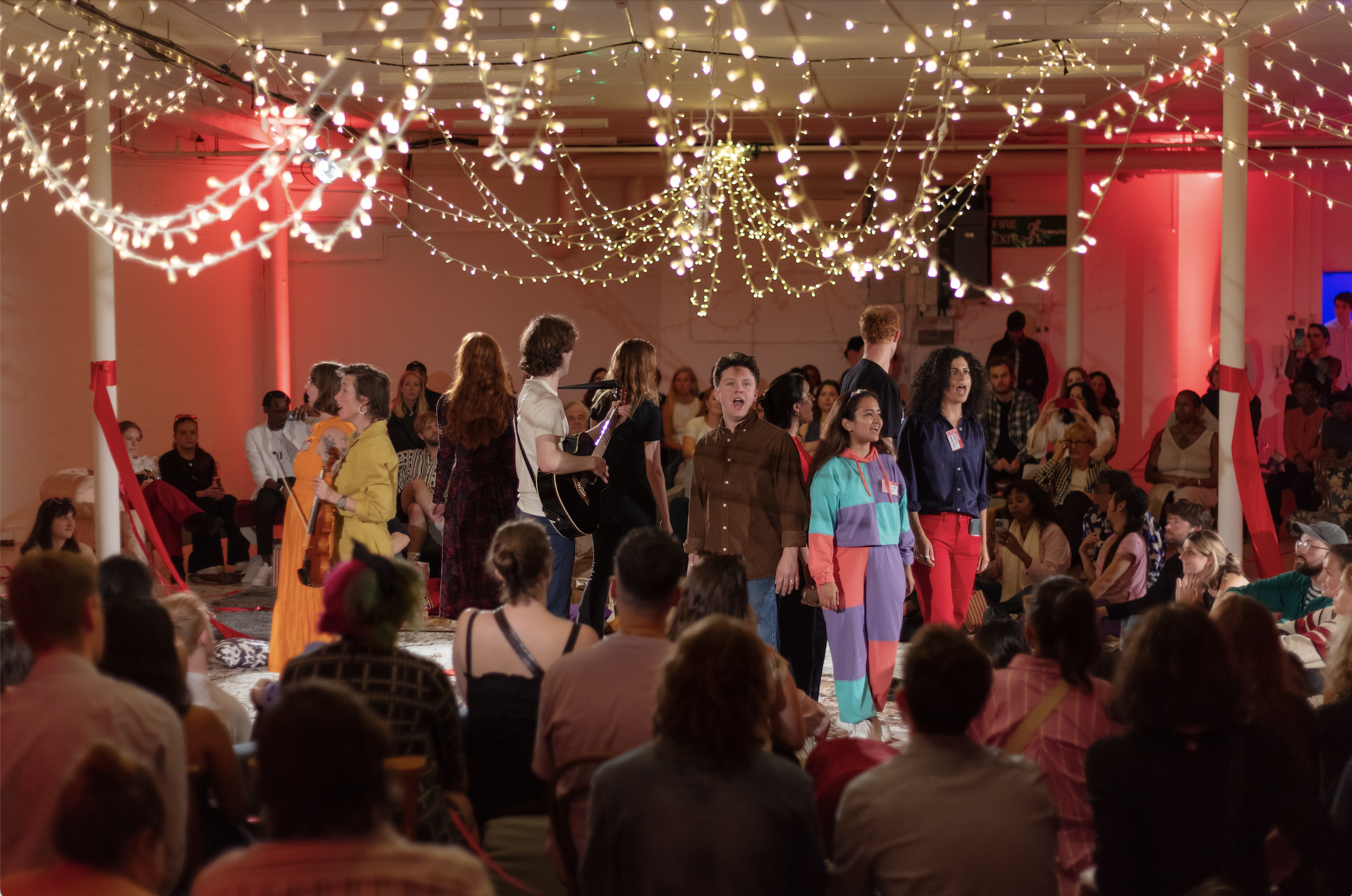 Vibrant warehouse event space with fairy lights for immersive meetings and performances.