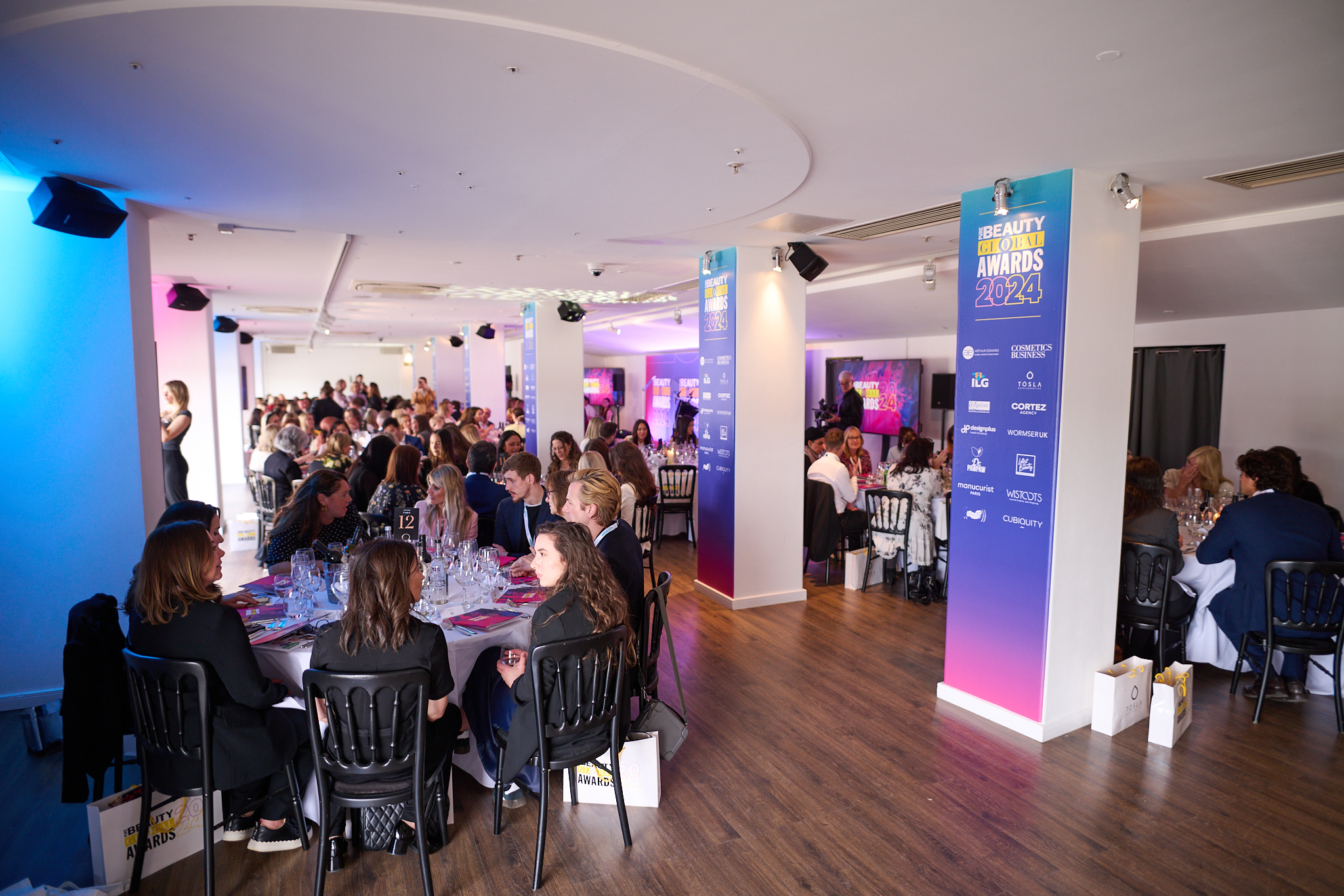 Awards ceremony in OXO2's West Wing with elegant round tables and vibrant lighting.