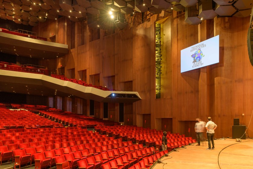 Concert hall with red seats, preparing for a large event and audience engagement.