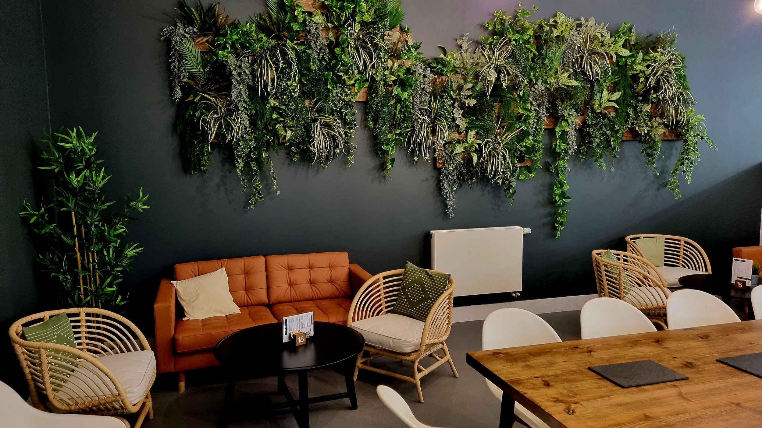 Stylish meeting space in Riverside Conferencing with vibrant vertical garden backdrop.