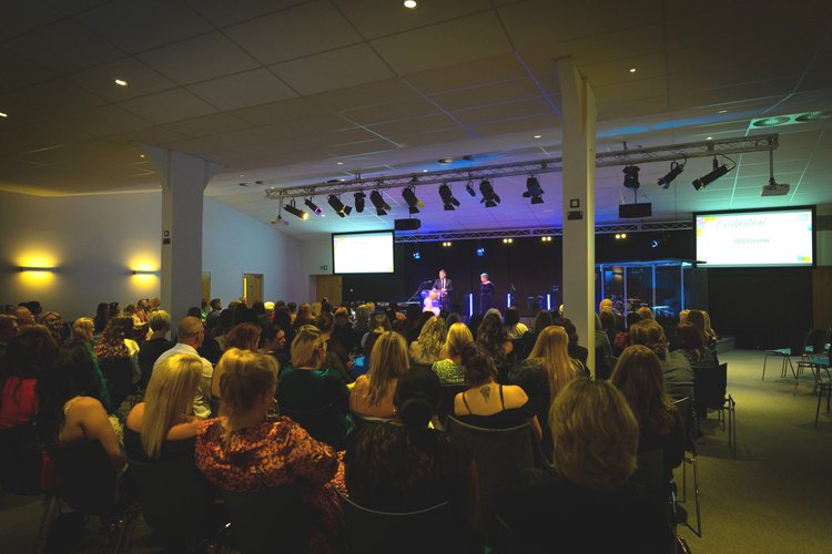 Riverside Conferencing auditorium event with professional lighting and engaged attendees.