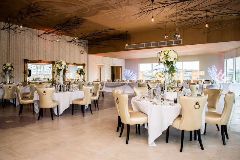 Elegant event space with round tables, ideal for weddings and corporate events.
