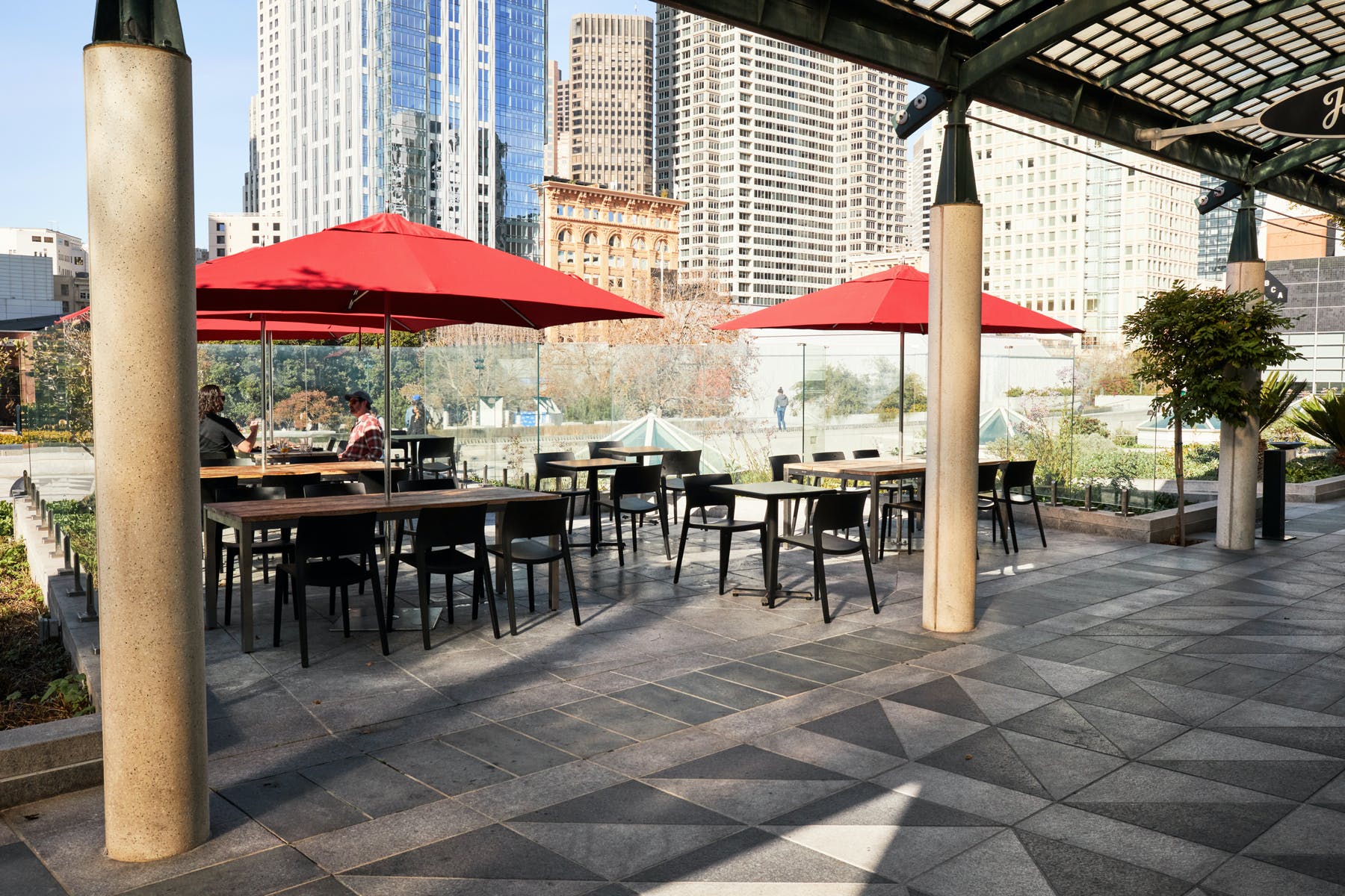Outdoor patio event space at Joyride Pizza with red umbrellas, perfect for corporate gatherings.