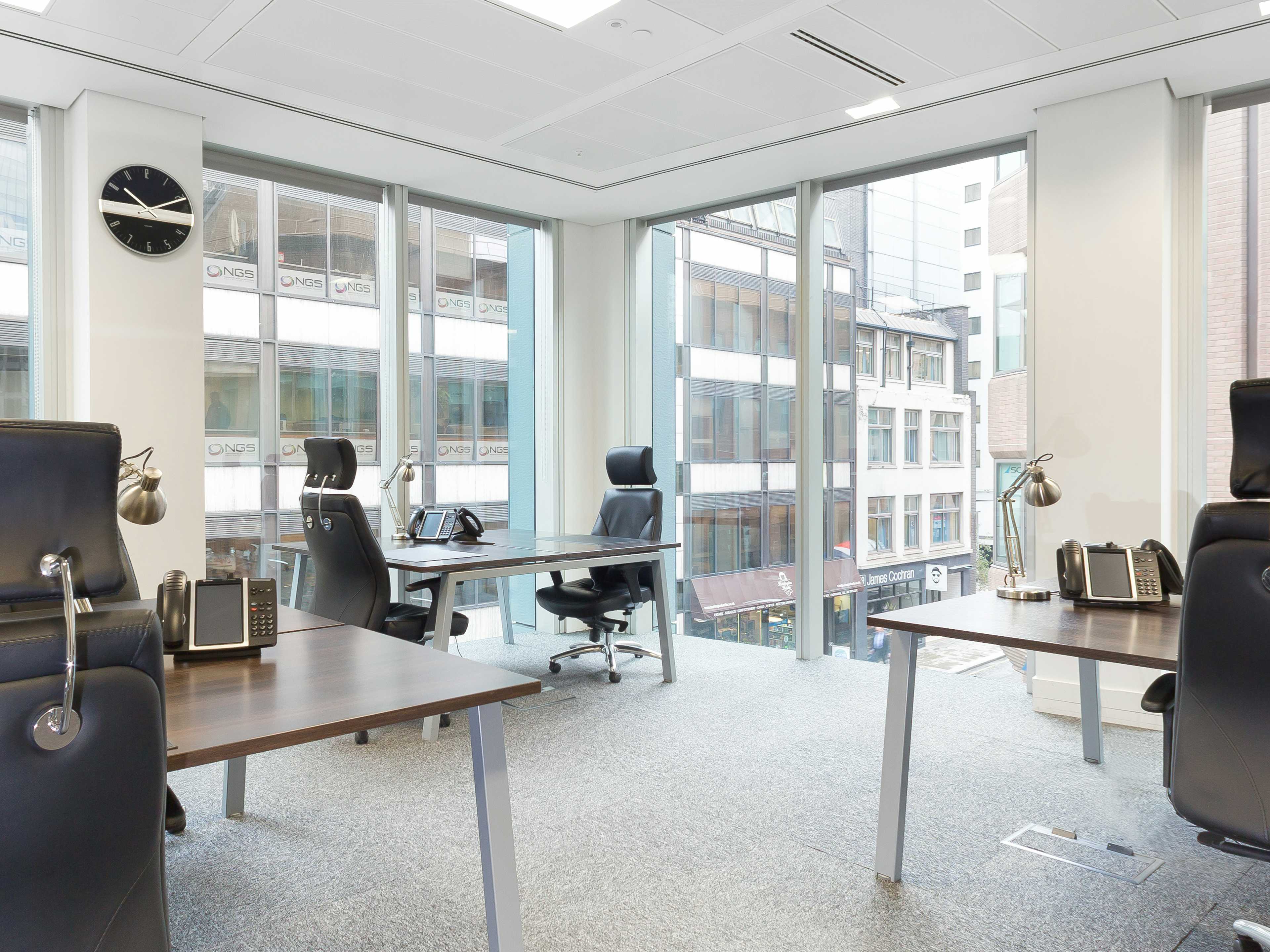 Modern private office with large windows, perfect for corporate meetings and hybrid events.