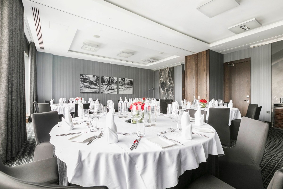 Private dining room at Brooklands Hotel with elegant round tables for corporate events.