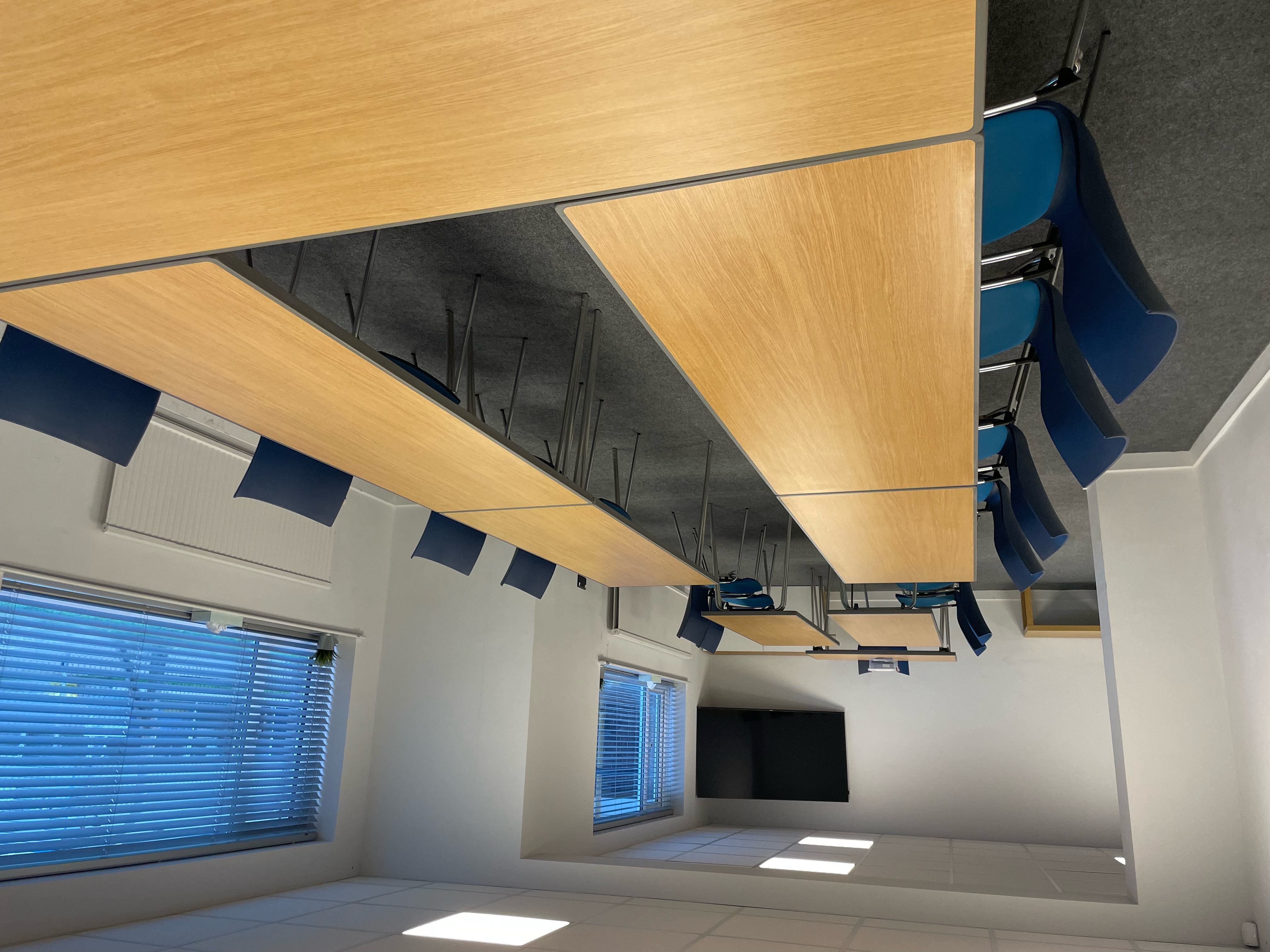 Flexible meeting room with blue chairs, ideal for workshops and team meetings.