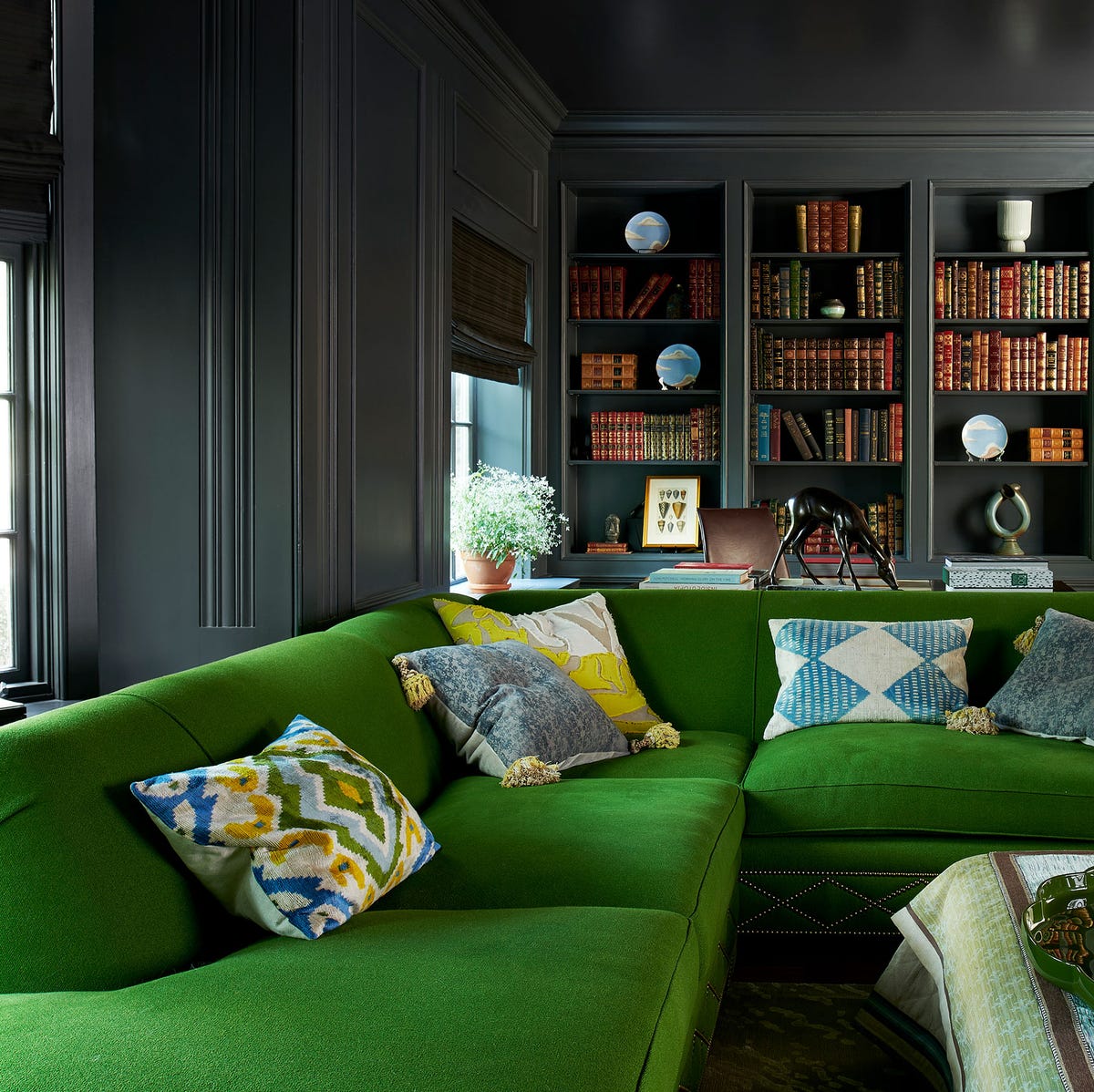 Sleek black lounge with vibrant green couch for creative meetings or brainstorming sessions.