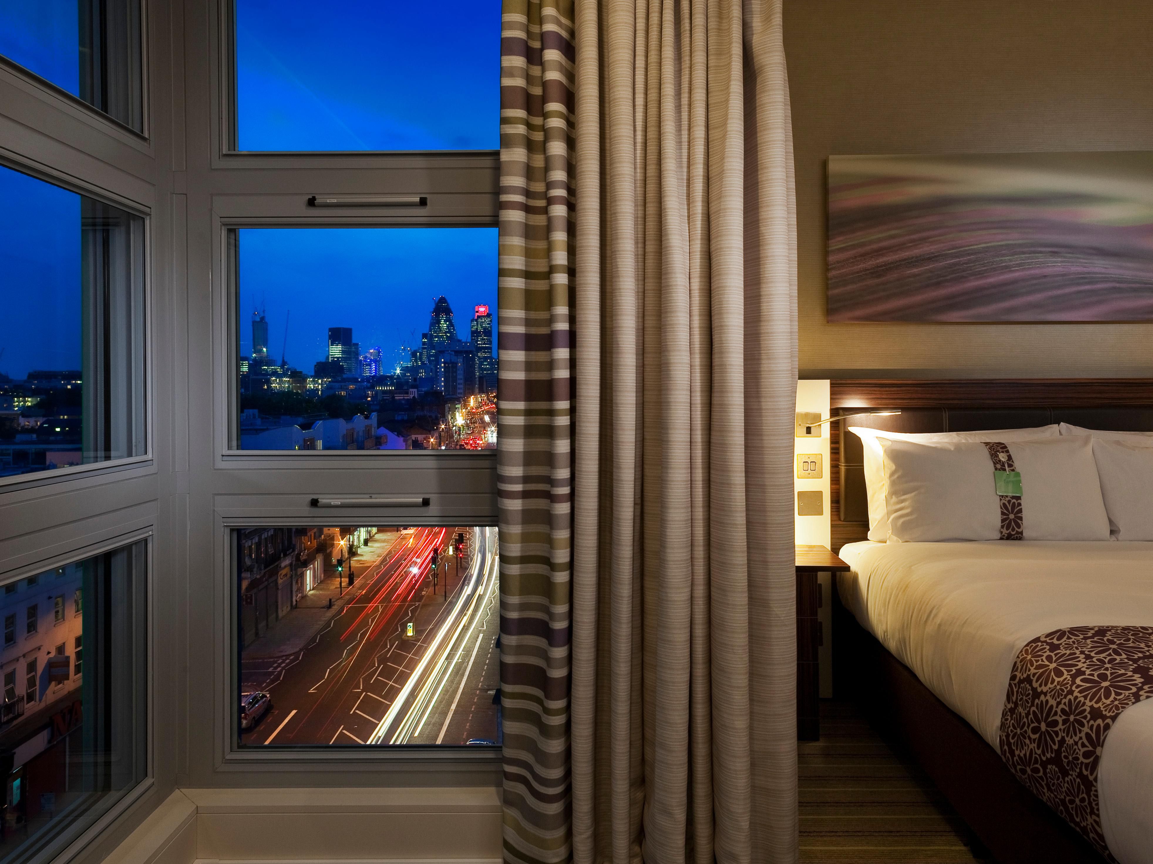 Modern hotel room in The Whitechapel Hotel with city skyline view, ideal for events.