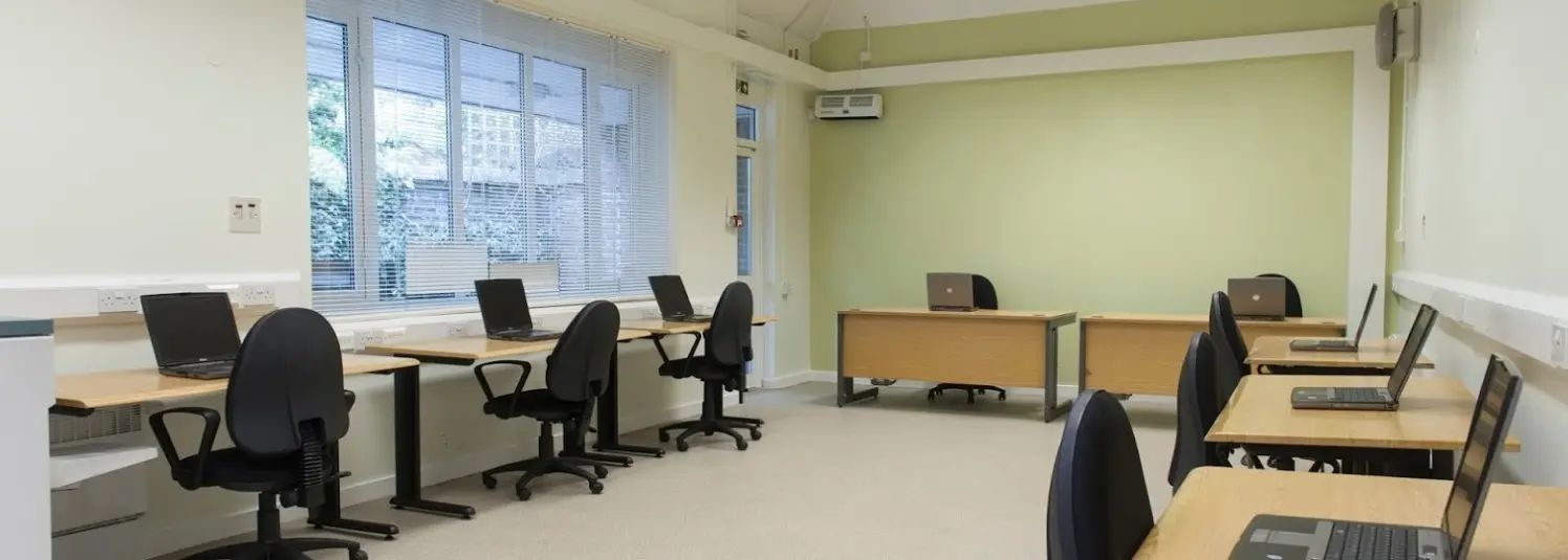 IT training room with computers and ergonomic chairs for workshops or meetings.