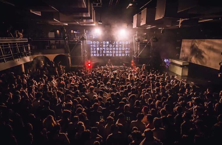 Crowd at vibrant concert in The LaLiT Ashok Bangalore auditorium, featuring professional lighting.