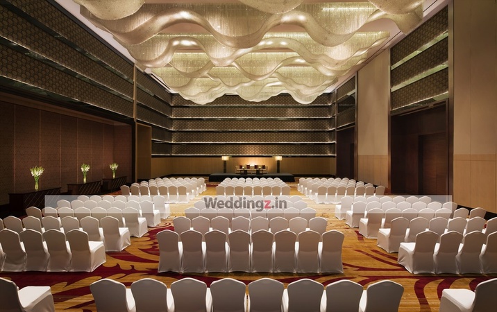 Auditorium at The LaLiT Ashok Bangalore with elegant white chairs, perfect for weddings and conferences.