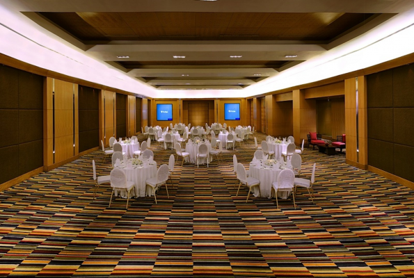 Spacious event space with round tables at Kalinga, The LaLiT Ashok Bangalore, ideal for banquets.