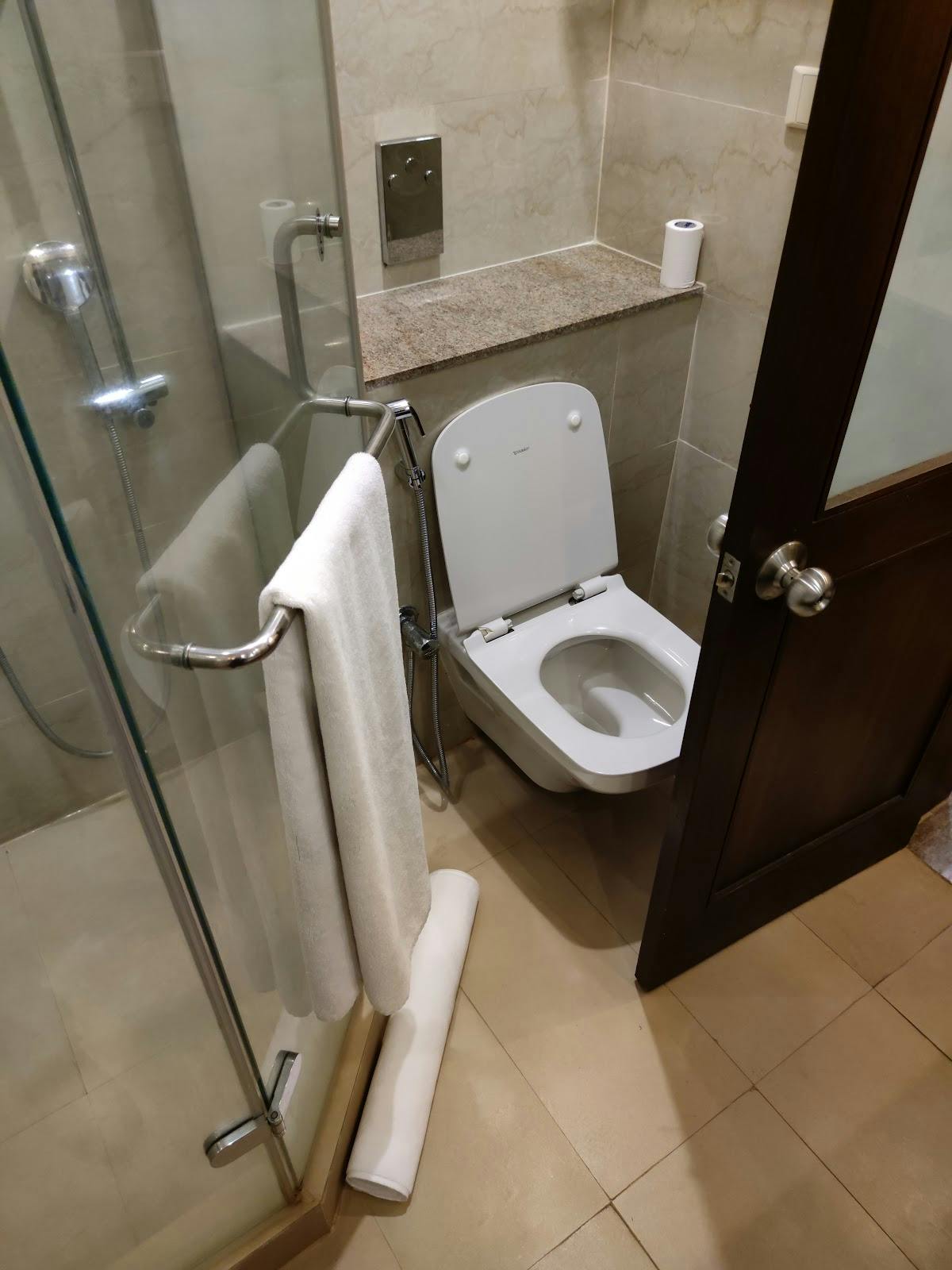 Modern restroom at The LaLiT Ashok Bangalore for events and meetings, featuring towel rack.