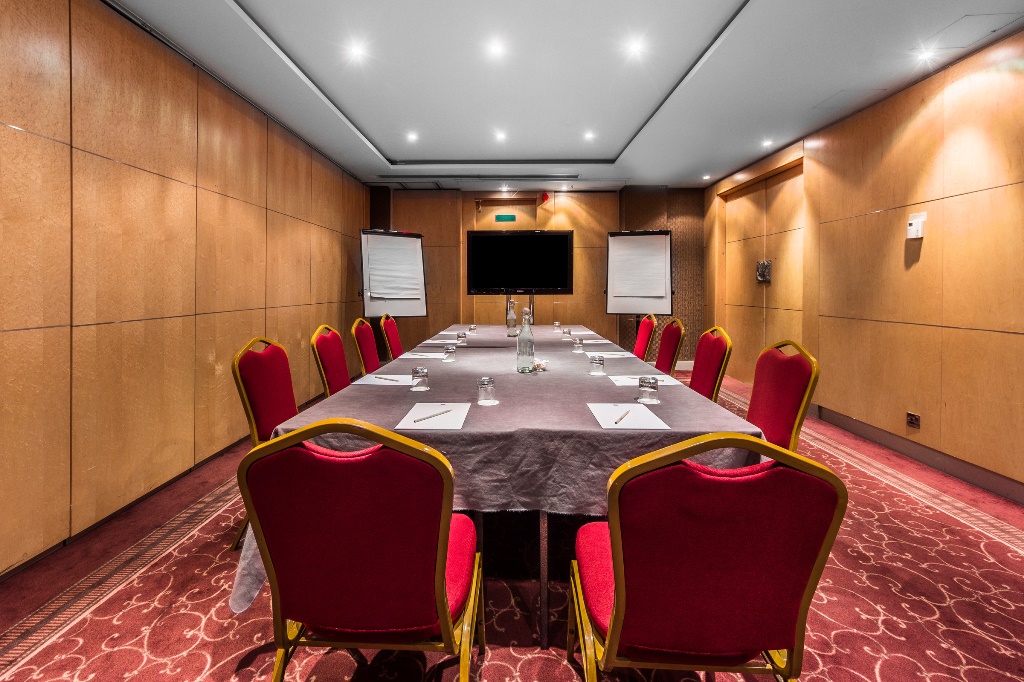 Meeting room at Courthouse Hotel with red chairs, perfect for workshops and conferences.