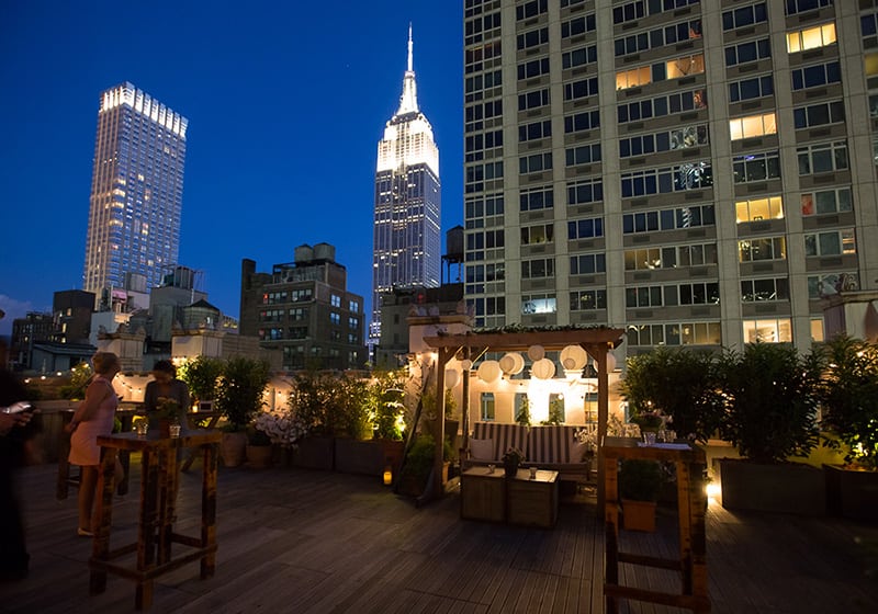 Rooftop bar at Refinery Hotel with Empire State backdrop, perfect for urban social events.