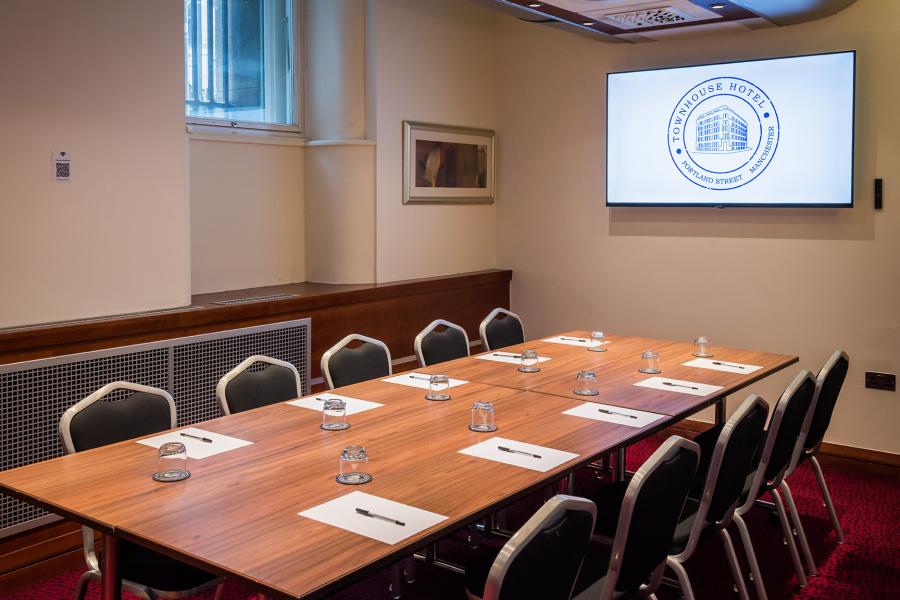 Meeting room with polished wooden table, ideal for corporate workshops in Novotel Manchester West.