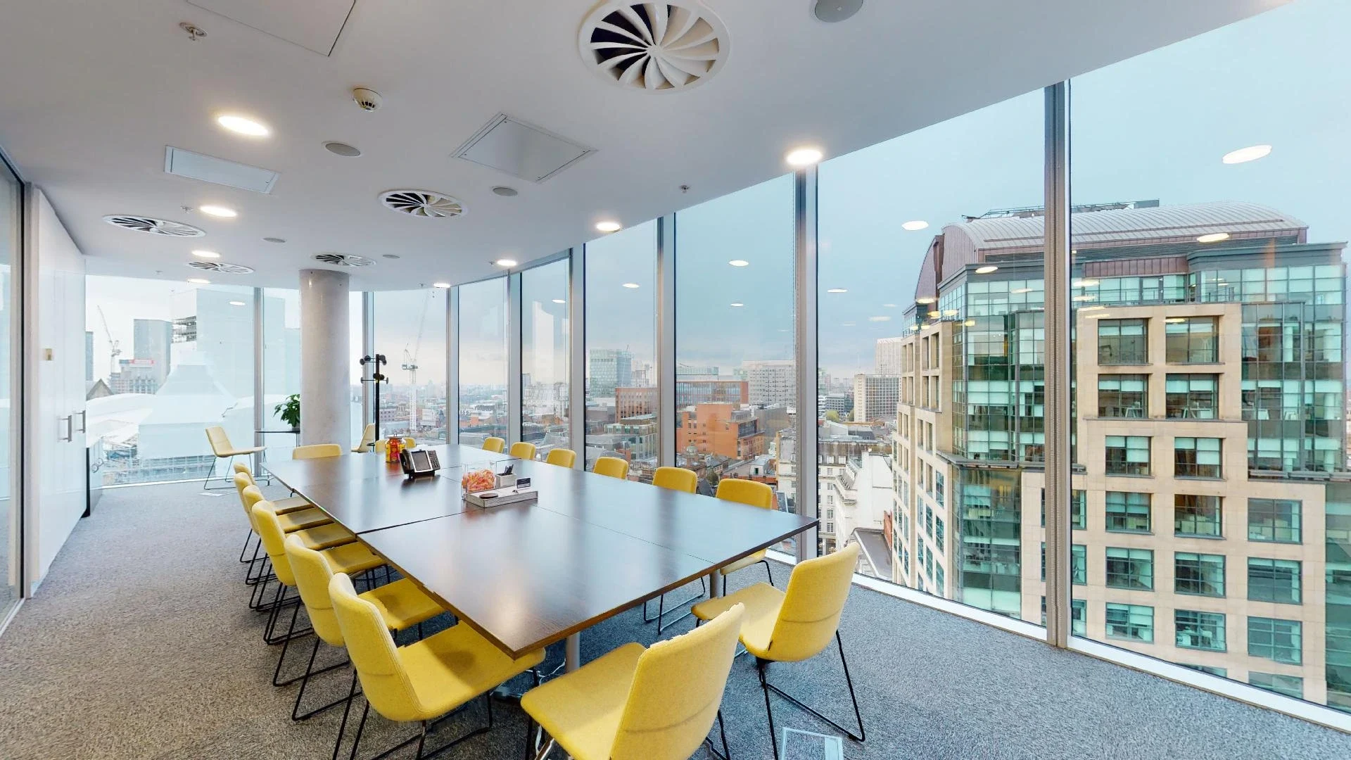 Modern meeting room with panoramic windows in Manchester's Landmark Offices. Ideal for presentations.