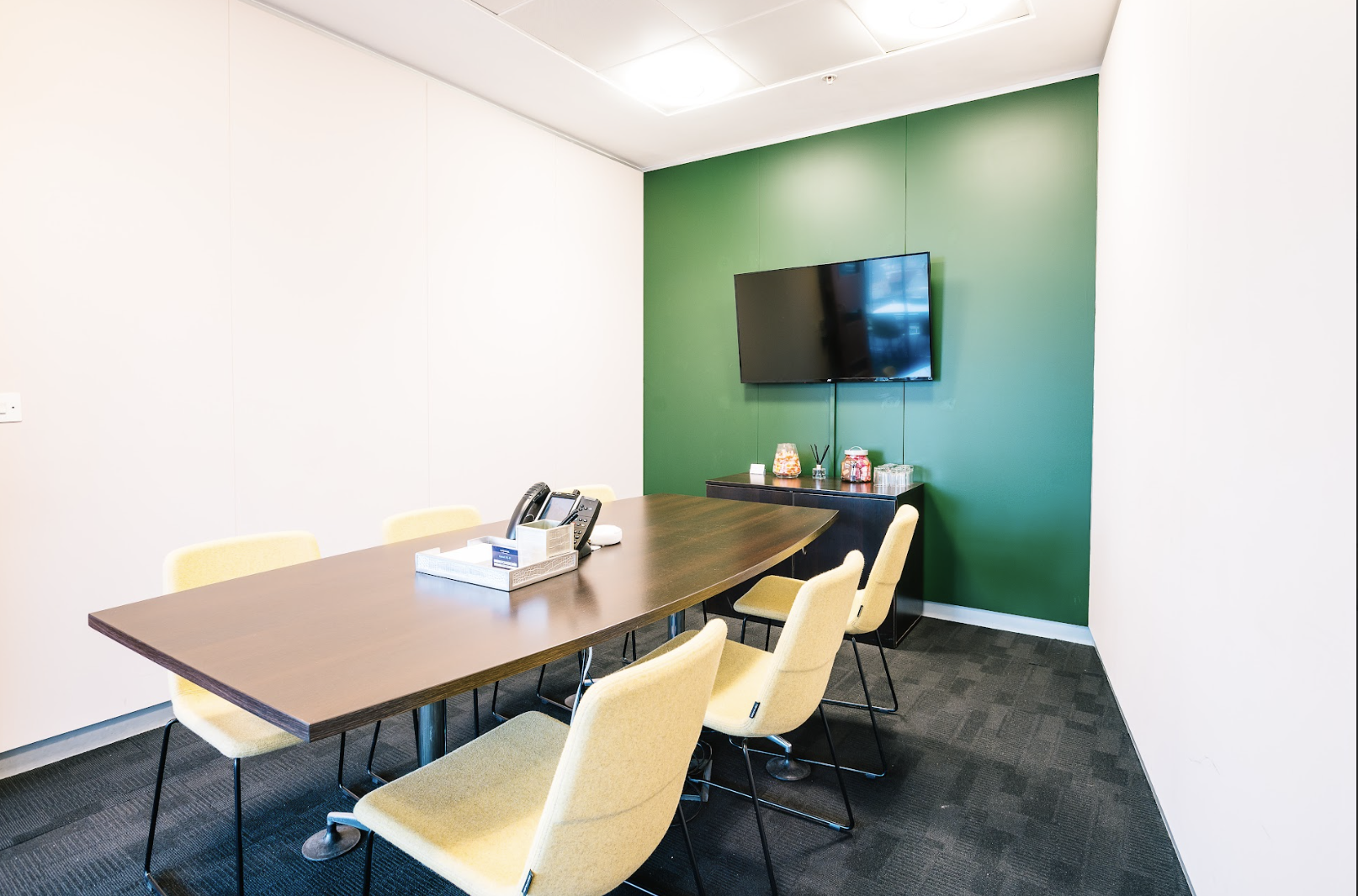 Modern meeting room with green wall in Landmark Offices, ideal for conferences and presentations.