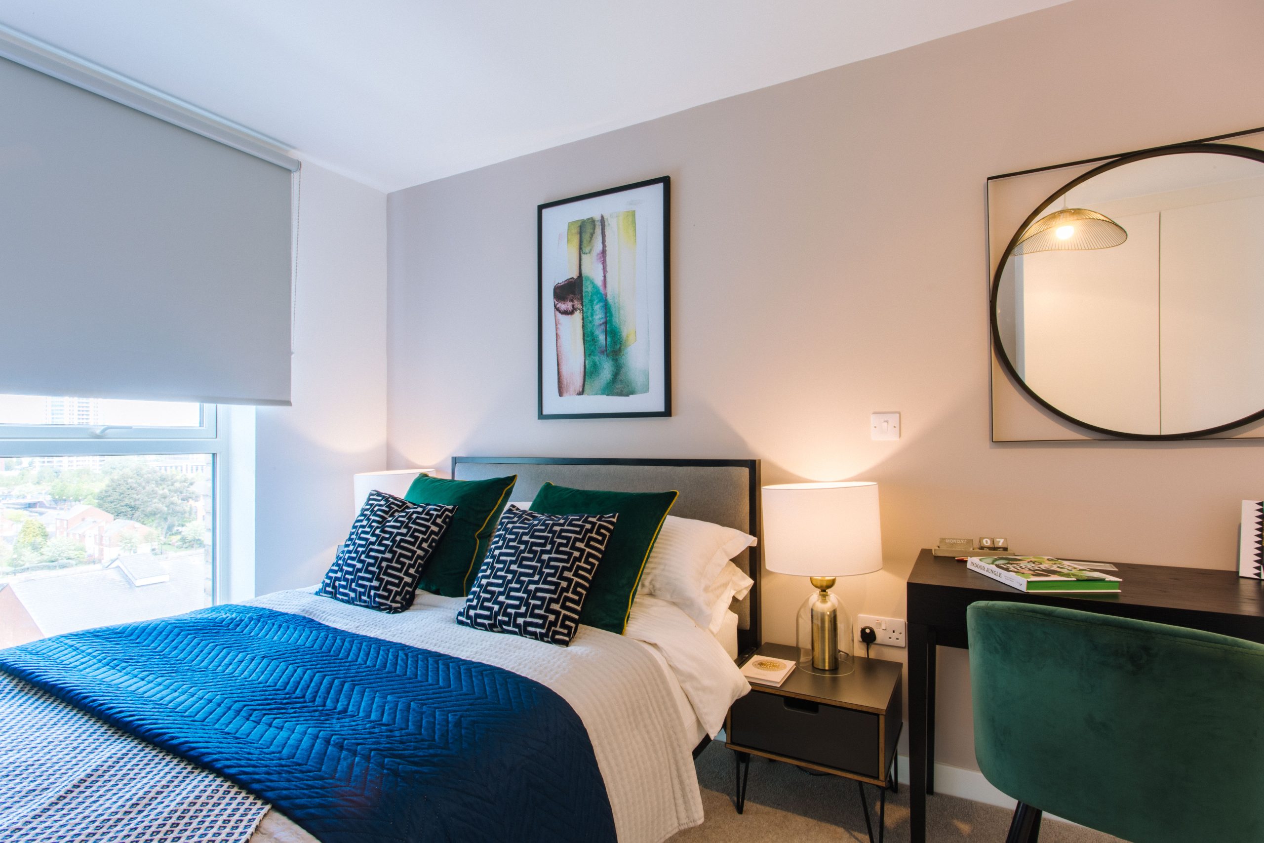 Modern hotel room with cozy bed and desk, perfect for business events and stays.