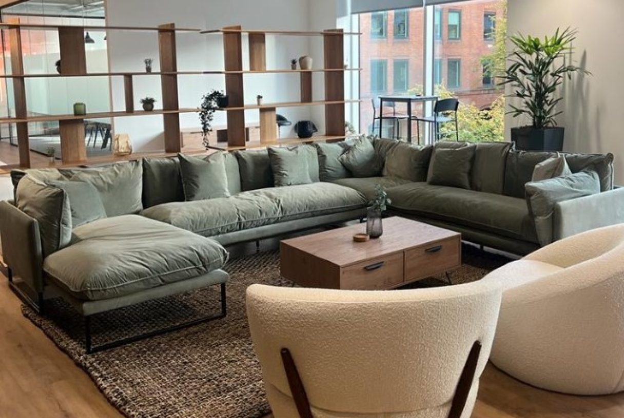 Modern lounge area with L-shaped sectional for networking and meetings.