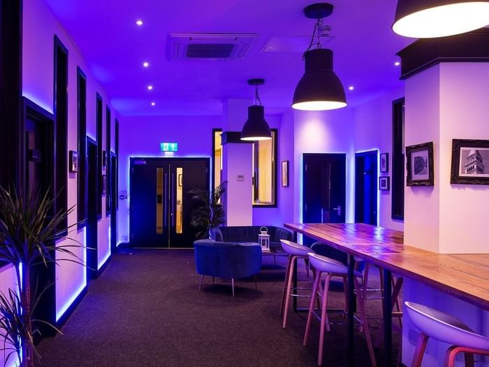 Modern conference room with ambient purple lighting for meetings and events.