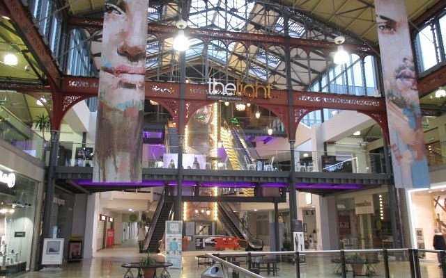 Modern event venue with soaring ceilings and vibrant murals, perfect for exhibitions and corporate events.